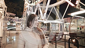 Young beautiful girl model in the evening at an amusement park.