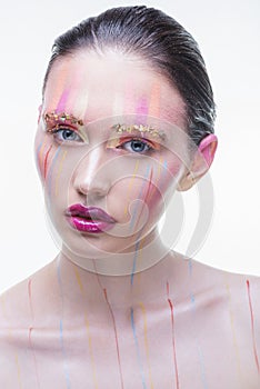 Young beautiful girl with multicolored splashes on his face photo