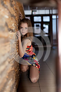 Young beautiful girl near the stone wall