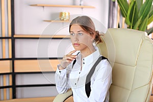 Young beautiful girl in office style looks at the camera.