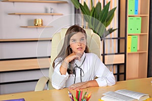Young beautiful girl in office style looks at the camera.
