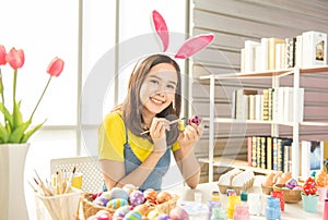 Young beautiful girl paint color on easter egg