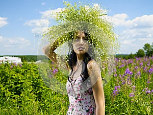 Young beautiful girl picks flowers in the field