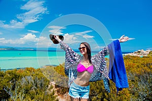 Young beautiful girl in pink bikini on a rock