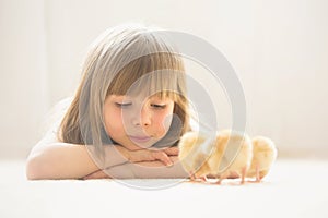 Young beautiful girl, playing with little newborn chick at home