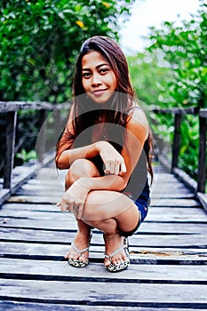 Young beautiful girl portrait on the wooden bridge in the mangrove forest