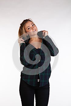 Young beautiful girl posing in the studio, standing in shirt