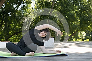 Young beautiful girl practicing yoga in a side pose on the street. Fitness in the park. Fitness for beginners