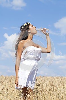 Young beautiful girl quenches thirst