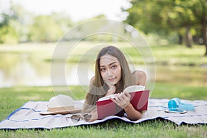 Young beautiful girl reading book in garden