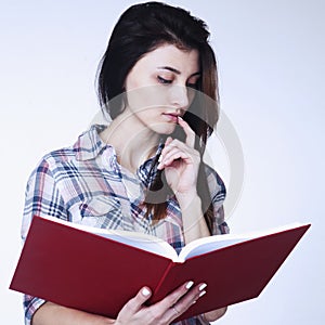 Young beautiful girl reading a book intdoors education, self de