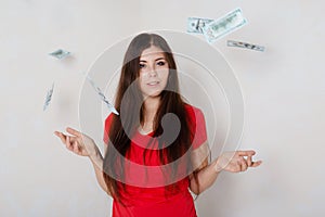 young, beautiful girl in a red t-shirt with money in hands. studio photo on a white background