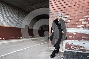 Young beautiful fashion girl shooting outdoors near brick wall at home