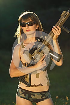 Young beautiful girl with a shotgun in an outdoor