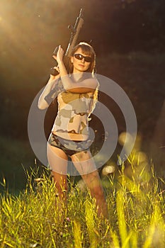 Young beautiful girl with a shotgun in an outdoor