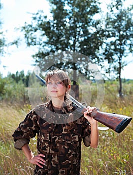 Young beautiful girl with a shotgun outdoor