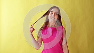 Young beautiful girl shows coming gesture, flirt, communication concept, yellow background.
