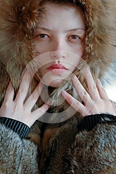 Young beautiful girl shows the photographer part her young body. A wolfskin jacket