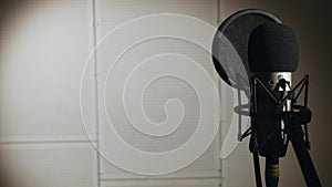 Young beautiful girl sings. Young singer singing into a microphone. Portrait close up of the singer. Recording studio