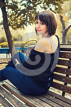 Young beautiful girl sitting on a bench