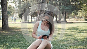 Young Beautiful Girl Sitting On Lawn In Park Using Tablet PC, On-line Shopping Concept