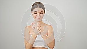 Young beautiful girl smiling confident applying skin lotion on hands over isolated white background