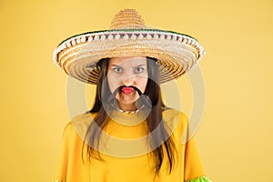 Young beautiful girl in sombrero  over yellow background.