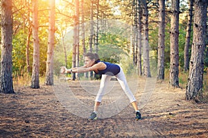 Young beautiful girl sports in the autumn forest at sunset