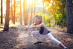 Young beautiful girl sports in the autumn forest at sunset