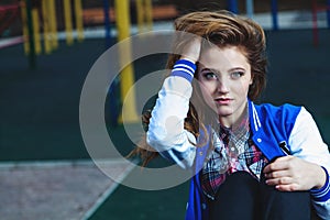 Young beautiful girl straightens her hair on playground