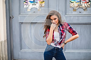 Young beautiful girl in stylish clothes posing in the city street