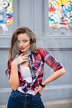 Young beautiful girl in stylish clothes posing in the city street