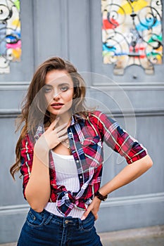 Young beautiful girl in stylish clothes posing in the city street