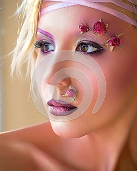 Young beautiful girl, stylish purple makeup and roses on face