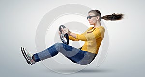 Young beautiful girl in sunglasses driver car with a wheel