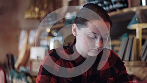 Young beautiful girl is surfing internet on phone in bar.