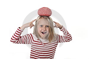 Young beautiful girl 6 to 8 years old playing with rubber brain having fun learning science concept