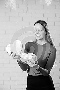 Young beautiful girl with Valentines day gift in heart shaped bo