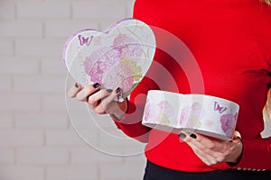 Young beautiful girl with Valentines day gift in heart shaped bo