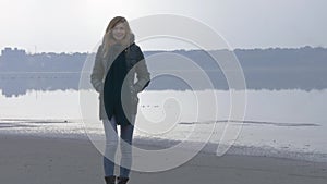 Young beautiful girl walking to camera and smiling in fog and mist. Back light