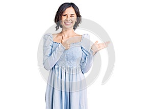 Young beautiful girl wearing casual clothes showing palm hand and doing ok gesture with thumbs up, smiling happy and cheerful