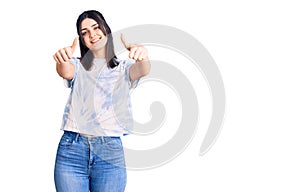 Young beautiful girl wearing casual t shirt approving doing positive gesture with hand, thumbs up smiling and happy for success