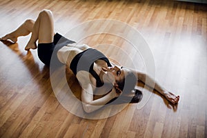 Young beautiful girl wearing fashion sports wear doing exercise on mat at loft gym, top view