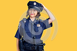 Young beautiful girl wearing police uniform confuse and wonder about question