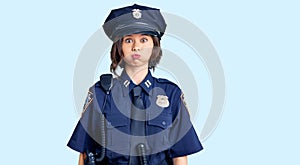 Young beautiful girl wearing police uniform puffing cheeks with funny face