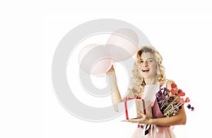 Young beautiful girl with a white gift with a red bow, flowers and balls in her hands rejoices on an isolated white background.