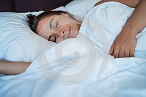 Young beautiful girl or woman sleeps alone in big bed, close up