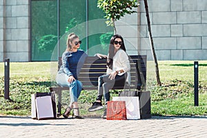 Beautiful girls with paper bags outside shopping mall