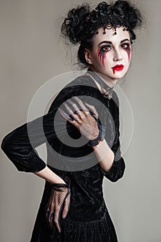 Young beautiful gothic woman with white skin and red lips. Halloween