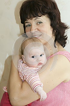 young beautiful grandmother holding her infant granddaughter